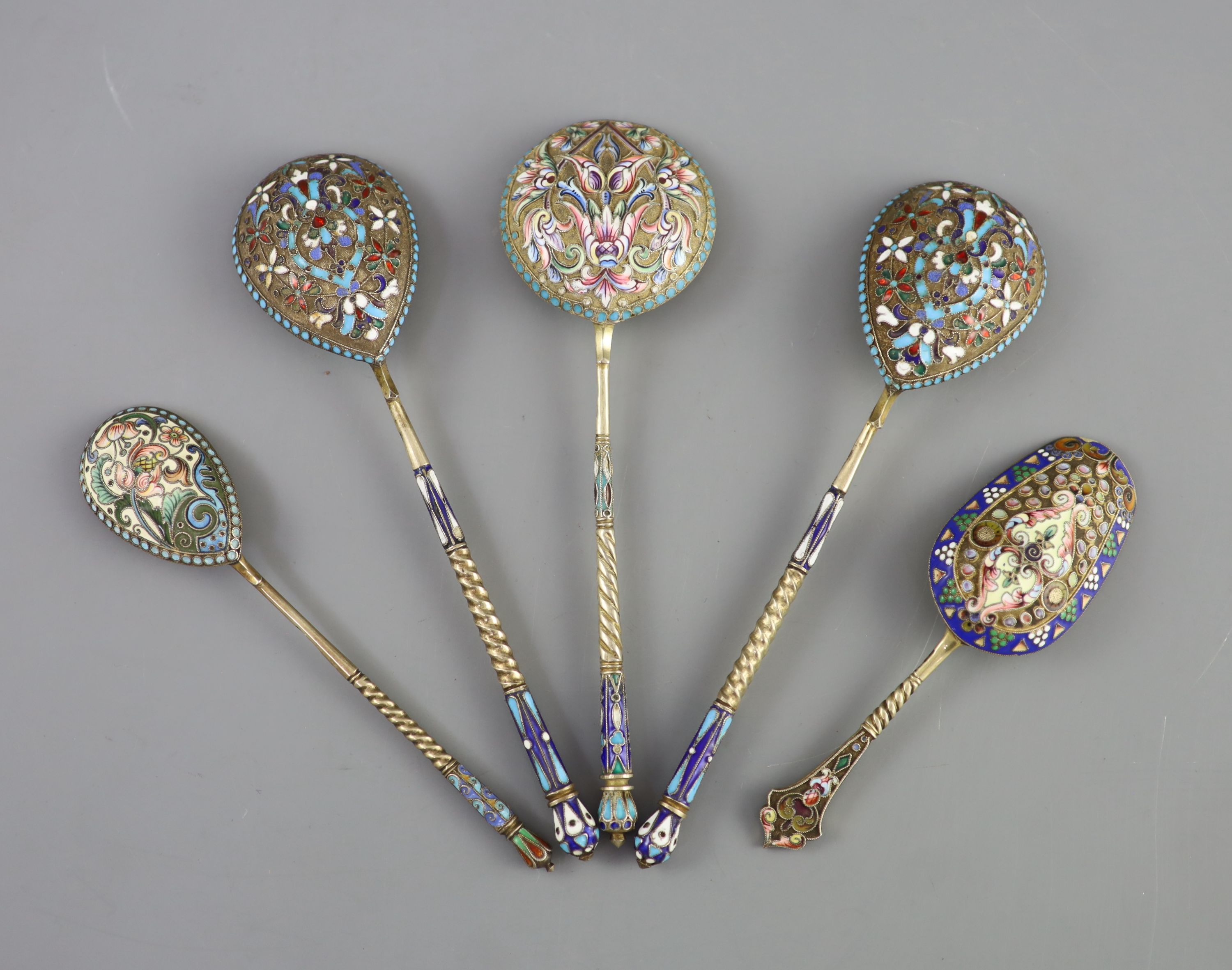 Five assorted late 19th/early 20th century Russian 84 zolotnik silver gilt and cloisonne enamel spoons and a similar napkin ring